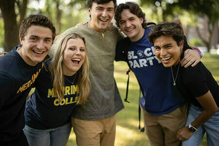 5 students with arms around each other laughing